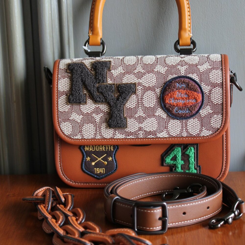 NWT Rogue Top Handle in Signature Textile Jacuard with Varsity Patches.
